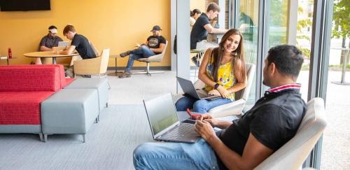 Students talking 和 working in RIC building lobby